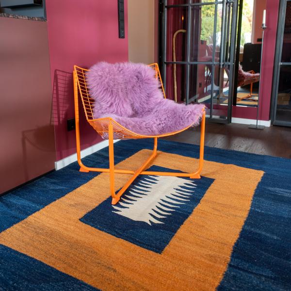 Moderne bolig med håndknyttet Gabbeh tæppe i mørkeblå, gul og hvid, kombineret med ora.